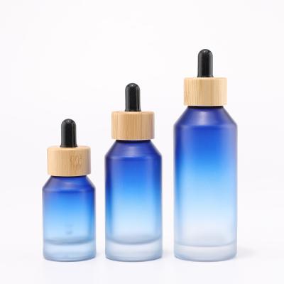 Gradient blue glass bottle with bamboo dropper for cosmetic packaging