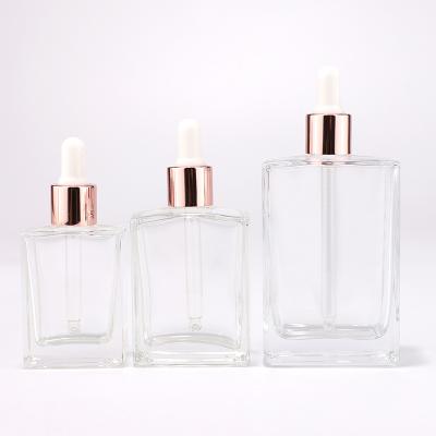 Rectangular clear glass bottle with aluminum rose gold dropper