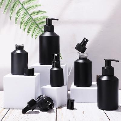 Slanted shoulder matte black glass bottle and jar packing